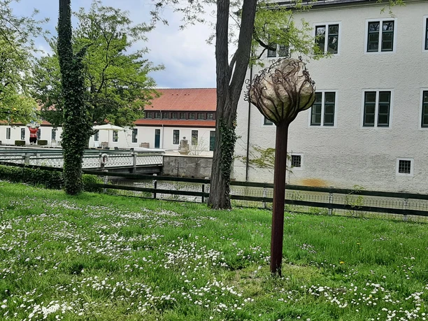 Schloss Benkhausen Skulptur im Park des Schlosses Benkhausen, umgeben von grüner Wiese und blühenden Bäumen.