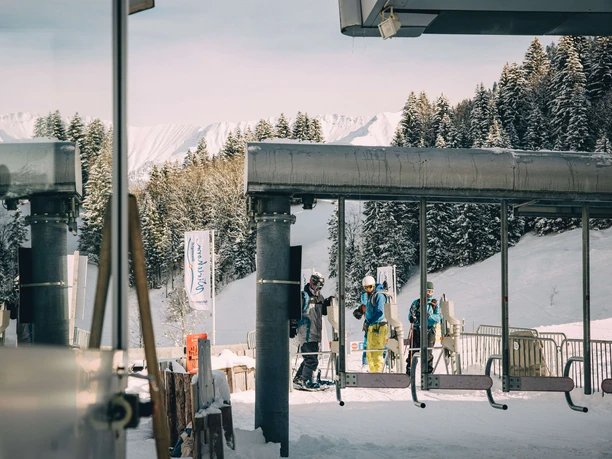 Der Sessellift der Wiriehornbahnen AG Skifahrer stehen vor dem Drehkreuz des Sesselliftes