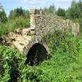Vierbogenbrücke Herrengraben Steinbrücke mit vier Bögen, umgeben von dichter Vegetation, verbindet historische Wanderwege.