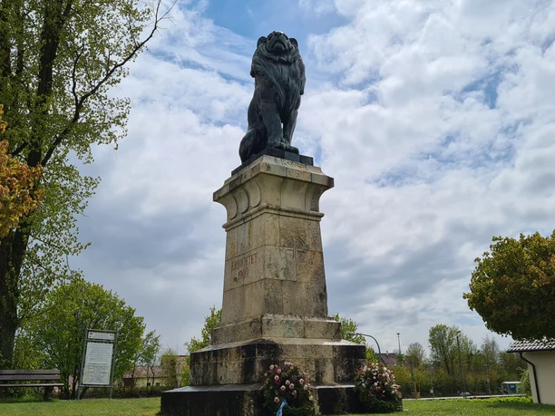 Der Löwe von Eggmühl Denkmal "Löwe von Eggmühl" auf hohem Sockel, umgeben von blühenden Bäumen.