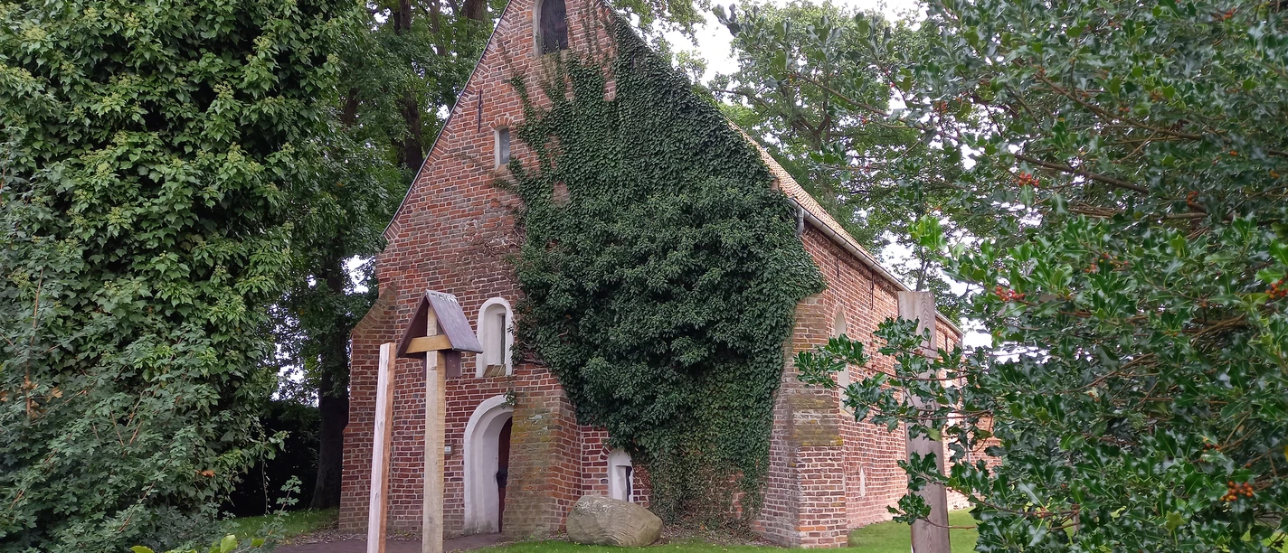 Kapelle Bokelesch Die kleine Kirche, idyllisch umgeben von üppigem Grün und Efeu, wirkt wie ein versteckter Schatz in der friedlichen Landschaft Niedersachsens. Der rote Backstein, teilweise von Pflanzen überwuchert, erzählt von Geschichten aus vergangenen Zeiten. Dies ist ein Ort der Stille, ideal für eine ruhige Einkehr oder um einfach nur die beruhigende Atmosphäre zu genießen. Der umliegende Garten lädt zu einem besinnlichen Spaziergang ein und bietet eine perfekte Kulisse für Momente der Besinnung und des Nachdenkens. Der Glockenturm erhebt sich dezent über die Bäume und verleiht dem kleinen Gebäude eine erhabene Anmut. Dies ist nicht nur ein Ort des Gebets, sondern auch ein Zeugnis der architektonischen Einfachheit und Schönheit vergangener Jahrhunderte. Ein Besuch dieser malerischen Kirche bietet sowohl kulturellen Reichtum als auch die Möglichkeit, die Schönheit der Umgebung zu genießen. Ob für stille Momente des Alleinseins oder um die Spiritualität des Ortes zu spüren, diese Kirche strahlt eine unvergessliche Ruhe und zeitlose Eleganz aus.