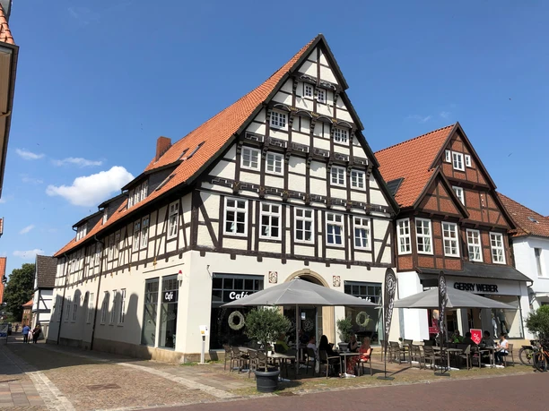 Fachwerkhaus in Bückeburg mit markantem Satteldach und Café im Erdgeschoss bei Sonnenschein.