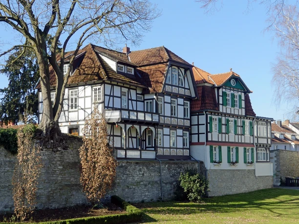 Fachwerkhäuser am Busdorfwall Paderborn Historische Fachwerkhäuser am Paderborner Busdorfwall, umgeben von Natur und alten Steinmauern.