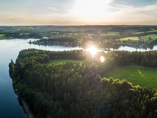 Bevertalsperre Luftaufnahme vom idyllischen Beversee bei Sonnenuntergang in Hückeswagen, umgeben von üppigen Wäldern.