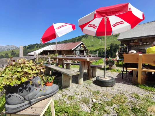 Berghaus Grimmi terrace Rotweisse Sonnenschirme, Tische und Bänke auf der BerghausterrasseRed and white parasols, tables and benches on the Berghaus terraceParasols rouges et blancs, tables et bancs sur la terrasse du Berghaus
