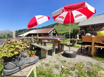 Berghaus Grimmi terrasse Parasols rouges et blancs, tables et bancs sur la terrasse du Berghaus