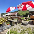 Berghaus Grimmi Terrasse Rotweisse Sonnenschirme, Tische und Bänke auf der BerghausterrasseRed and white parasols, tables and benches on the Berghaus terraceParasols rouges et blancs, tables et bancs sur la terrasse du Berghaus