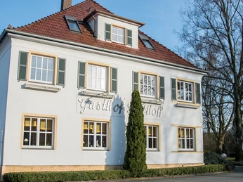 Gasthof Potthoff Das Gasthof Potthoff ist ein zweistöckiges, weißes Gebäude mit grünen Fensterläden und roten Dach.