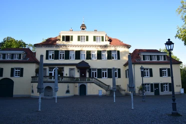Schloss Eulenbroich <p>Historisches Herrenhaus in Rösrath mit symmetrischer Fassade und geschlossenem Sonnenschirmstühlen.</p>