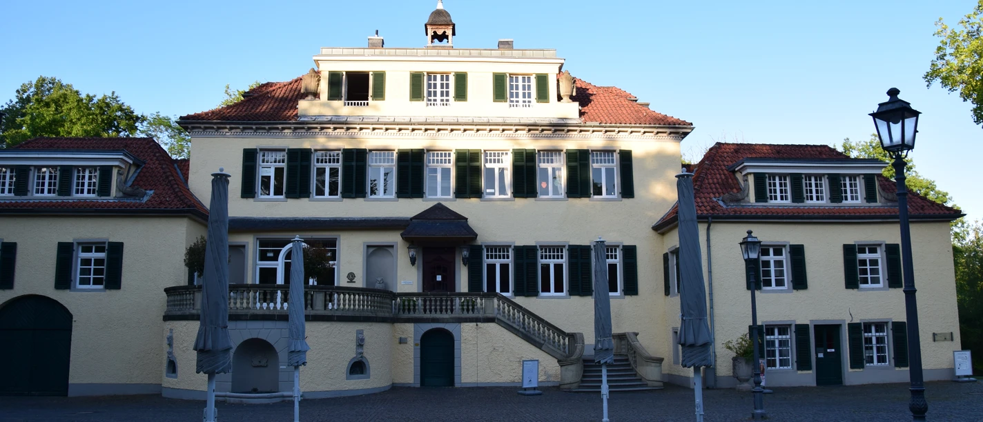 Schloss Eulenbroich <p>Historisches Herrenhaus in Rösrath mit symmetrischer Fassade und geschlossenem Sonnenschirmstühlen.</p>