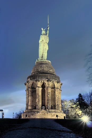 Hermannsdenkmal Beleuchtetes Hermannsdenkmal bei Nacht, umgeben von Bäumen, unter einem klaren Nachthimmel.