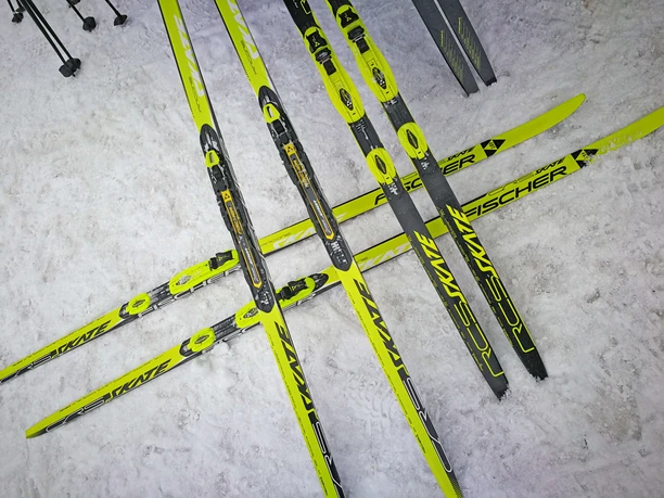 Cross-country skis ready for use Langlaufskis liegen gekreuzt auf dem verschneiten Boden