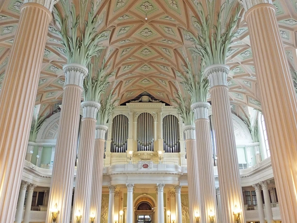 LR_Leipzig_Nikolaikirche_Wolfgang Gärtner_verkleinert-DSCF3171.jpg Innenansicht der Leipziger Nikolaikirche mit Säulen, bemalter Decke und Orgel im Hintergrund.