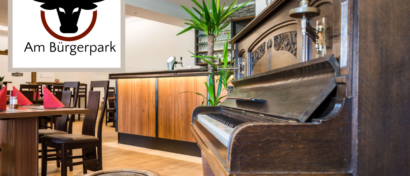 Steakhaus Am Bürgerpark Werlte Innenraum des Steakhaus Am Bürgerpark Werlte mit Holzmöbeln, altem Klavier und stilvoller Theke