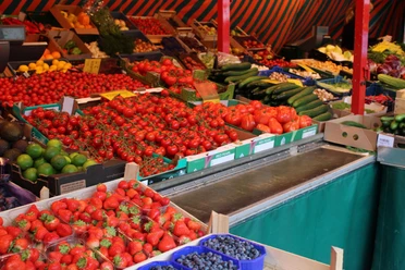 Wochenmarkt in Rastede Marktstand mit großer Auswahl an frischem Obst und Gemüse wie Erdbeeren, Tomaten und Gurken.