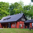 Museum Peter August Böckstiegel, Künstlerhaus Ein charmantes, rotes Fachwerkhaus mit Schieferdach, umgeben von dichtem grünen Wald.