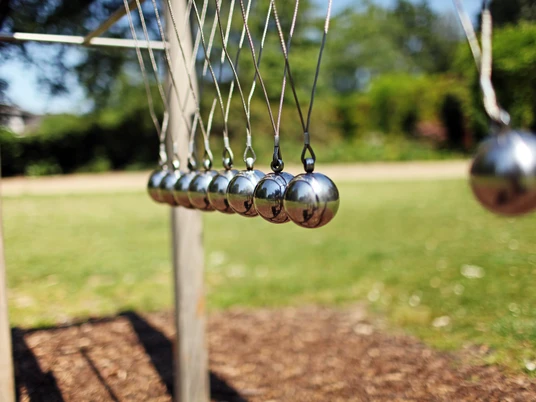 Klangelemente im Kurpark in Bad Laer Kunstinstallation mit mehreren schwingenden Metallkugeln im Freien auf Rasenfläche.Art installation with several swinging metal spheres outdoors on a lawn.Kunstinstallation med flere svingende metalkugler udendørs på en græsplæne.Kunstinstallatie met verschillende schommelende metalen bollen buiten op een grasveld.