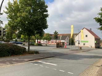 Parkplatz Mengersenstraße Parkplatz an einer ruhigen, grünen Straße mit Gebäuden. Einige Autos und Bäume im Hintergrund.