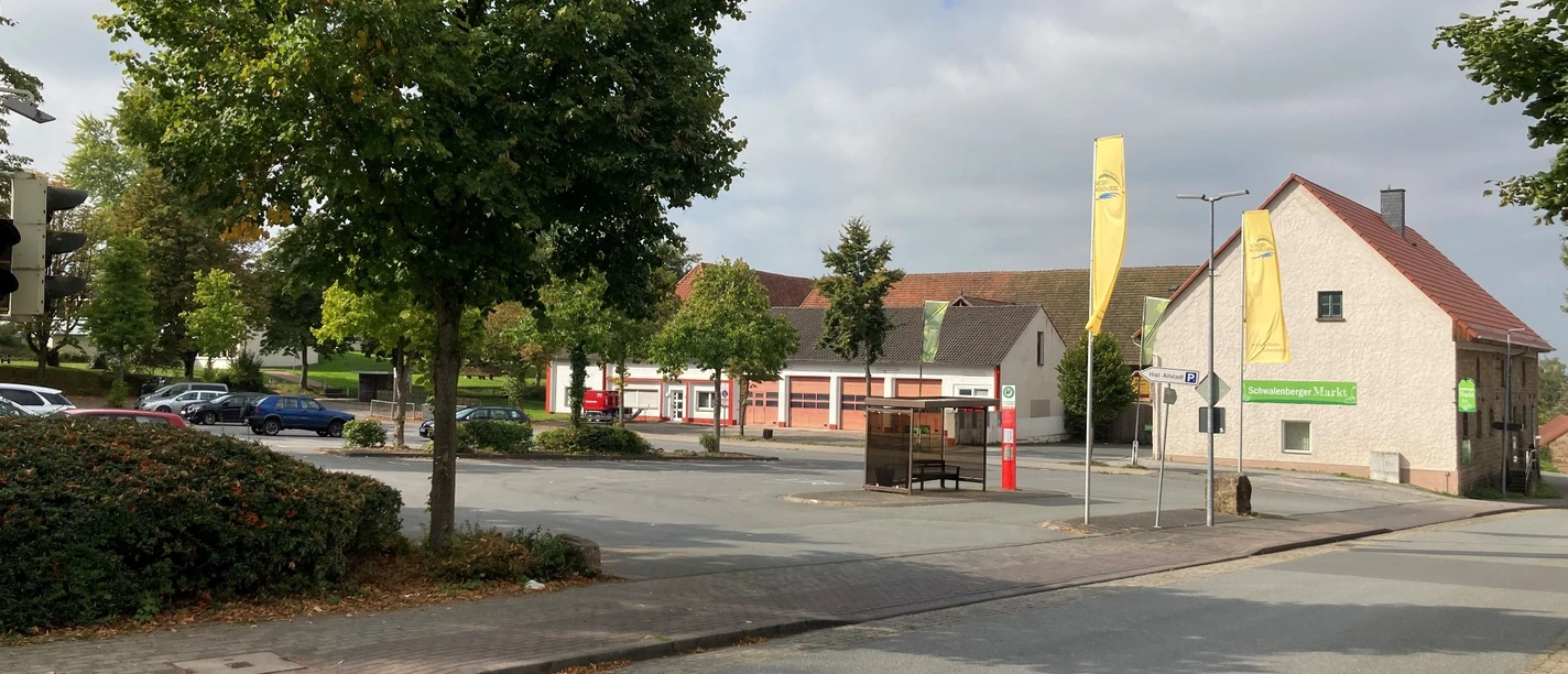 Parkplatz Mengersenstraße Parkplatz an einer ruhigen, grünen Straße mit Gebäuden. Einige Autos und Bäume im Hintergrund.