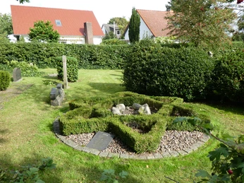 Historischer Jüdischer Friedhof in Achim, gepflegte Grünanlage mit älteren Grabsteinen und Hecken.