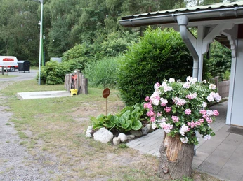 Ein Campingplatz mit Blumenarrangements und Bäumen, ideal für Naturliebhaber und Erholungssuchende.