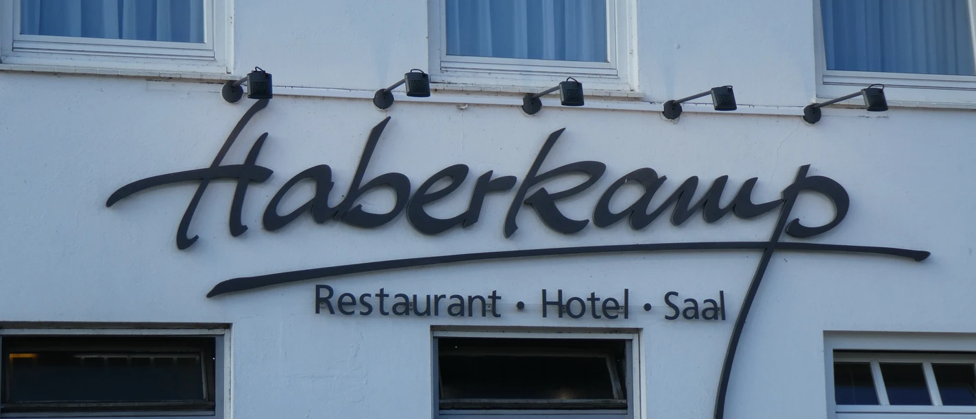 Haberkamp Hotel-Restaurant, white façade, large windows and a striking black logo on the wall.