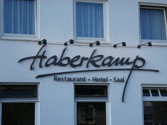 Haberkamp Hotel-Restaurant Haberkamp Hotel-Restaurant, weiße Fassade, große Fenster und ein markantes schwarzes Logo an der Wand.
