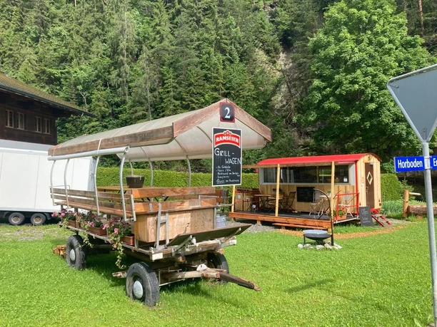 Barbecue trolley in Horboden Covered wagon on a green meadow with a kiosk in the background