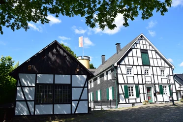 DSC_0391.JPG Fachwerkhäuser mit weißen Wänden und dunklen Balken unter blauem Himmel und grünem Laub.