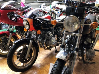 Klassische Motorräder der Marke Benelli stehen nebeneinander im Museum, umgeben von hellem Holzfußboden.