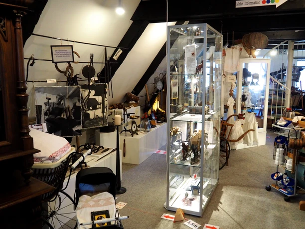Blick ins Heimatmuseum Im Heimatmuseum sind alte Werkzeuge, Bilder und Haushaltsgegenstände in Glasvitrinen ausgestellt.