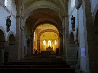 Blick auf den Altarraum der St.Kilianskirche, durch hohe Bögen und mit Statuen flankiert.