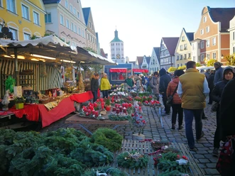 Ein belebter Jahrmarkt in Günzburg: Marktstände, Dekorationen und Besucher auf gepflastertem Weg.