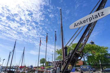 Der Ankerplatz in Büsum Ein alter kleiner Kran mit dem Schild "Ankerplatz"