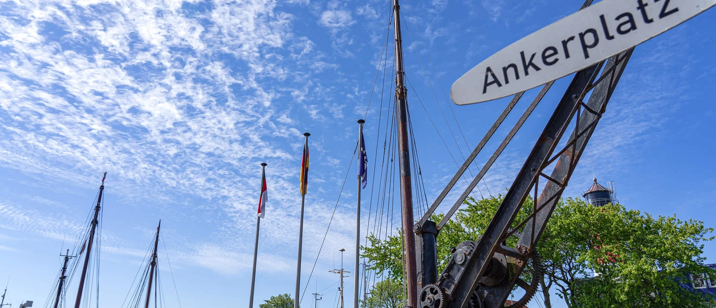 Der Ankerplatz in Büsum Ein alter kleiner Kran mit dem Schild "Ankerplatz"