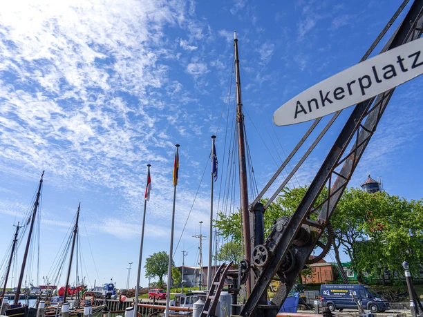Der Ankerplatz in Büsum Ein alter kleiner Kran mit dem Schild "Ankerplatz"