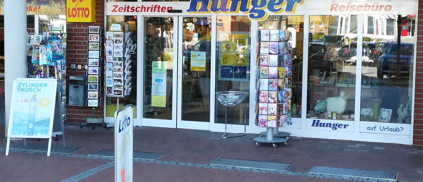 Eingangsbereich eines Reisebüros und Zeitschriftengeschäfts mit Lotto-Annahme und Postkartenständern in Cadenberge.