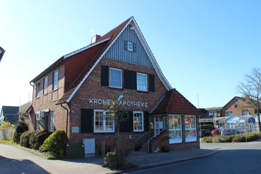Cadenberge Kronen-Apotheke Backsteinapotheke mit rotem Giebeldach und weißen Fensterrahmen im Zentrum von Cadenberge