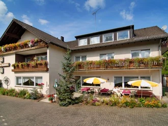Haus Waldblick Gemütliches Gästehaus im Landhausstil mit blumengeschmückten Balkonen und Sonnenterrasse.