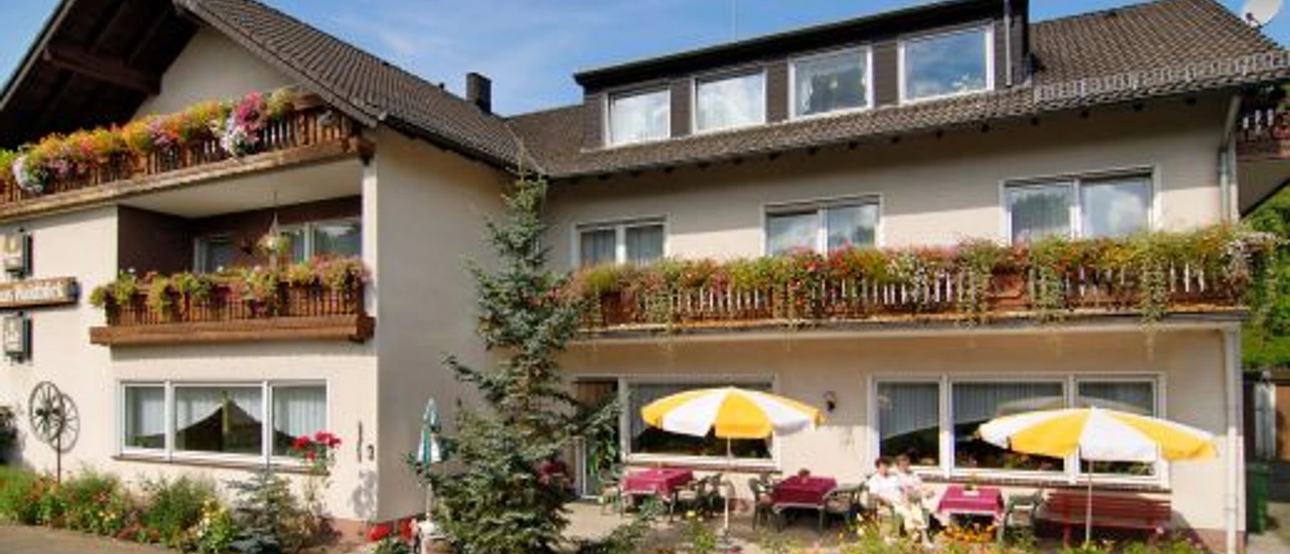 Haus Waldblick Gemütliches Gästehaus im Landhausstil mit blumengeschmückten Balkonen und Sonnenterrasse.