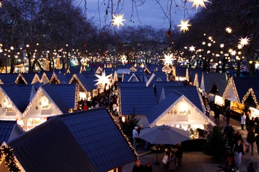 Markt der Engel in Köln Zauberhaft illuminierter Weihnachtsmarkt mit sternenförmigen Lichtern und Hütten unter freiem Himmel.