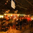 Weihnachtsmarkt im Stadtgarten Ein belebter Weihnachtsmarkt im Stadtgarten Köln bei Nacht, mit leuchtenden Ständen und Menschen.A lively Christmas market in Cologne's Stadtgarten at night, with illuminated stalls and people.