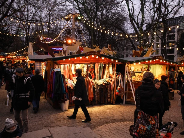 Stadtgarten Christmas market A Christmas market with stalls, lights and visitors in the evening light.