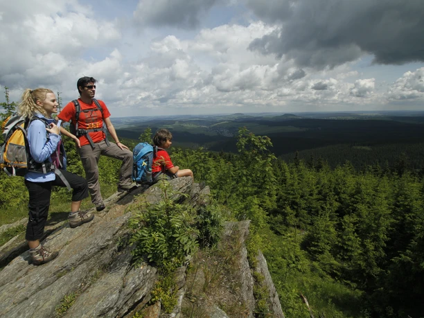Erzgebirge©Ingo Hübner.JPG Drei Wanderer genießen den Panoramablick auf das grüne Erzgebirge unter einer wolkigen Himmel.