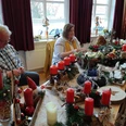 Weihnachtsmarkt Tange.jpg Menschen verkaufen Adventsgestecke mit roten Kerzen und Tannenzweigen auf einem Weihnachtstisch.People selling Advent arrangements with red candles and fir branches on a Christmas table.Folk sælger adventsarrangementer med røde lys og grangrene på et julebord.Mensen verkopen adventsarrangementen met rode kaarsen en dennentakken op een kersttafel.