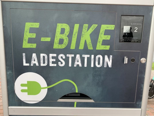 Symbolbild: E-Bike Ladestation "Ladestation für E-Bikes mit grünem Symbol in einem modernen Design, Ladekapazität für zwei Räder."