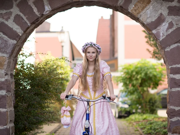 Dornröschen mit Fahrrad unter Torbogen.jpg
