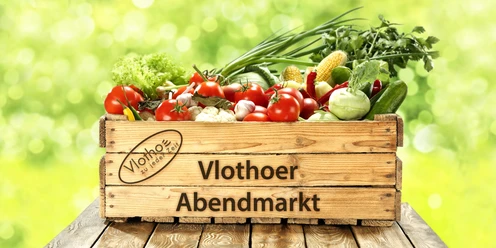 Eine Holzkiste voller bunter, frischer Gemüsearten wie Tomaten, Paprika und Mais vor grünem Hintergrund.