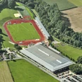 Luftaufnahme des Ahorn Sportparks mit erkennbarer Leichtathletikanlage und umgebender Natur.