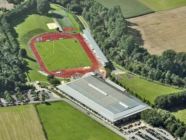 Luftaufnahme des Ahorn Sportparks mit erkennbarer Leichtathletikanlage und umgebender Natur.